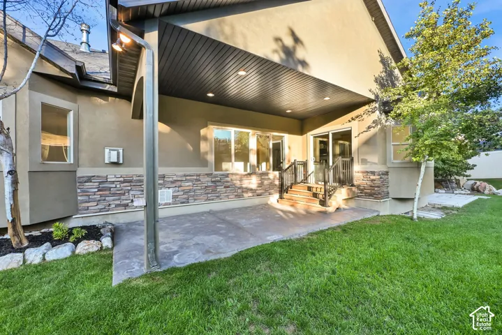Covered patio with recessed lighting, stone veneer accents, and a concrete patio surface