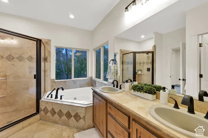 Dual vanity with integrated sinks, wood cabinetry, and a large wall-mounted mirror