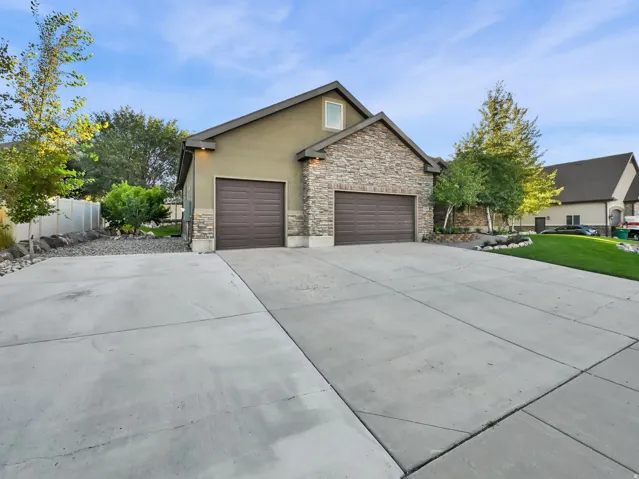 Stucco and stone exterior with a two-car garage