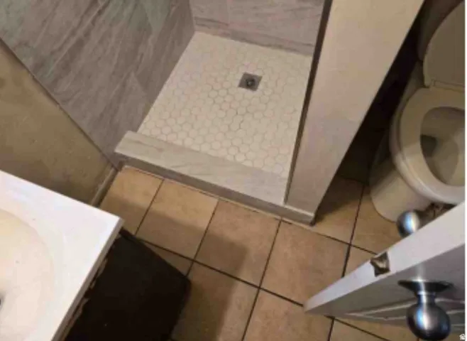 Shower with gray wall tiling and hexagonal floor tiling