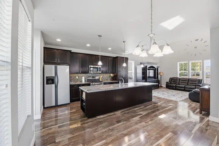 Gourmet kitchen with dark wood-finish cabinetry, stainless steel appliances, and a central island with a solid surface countertop