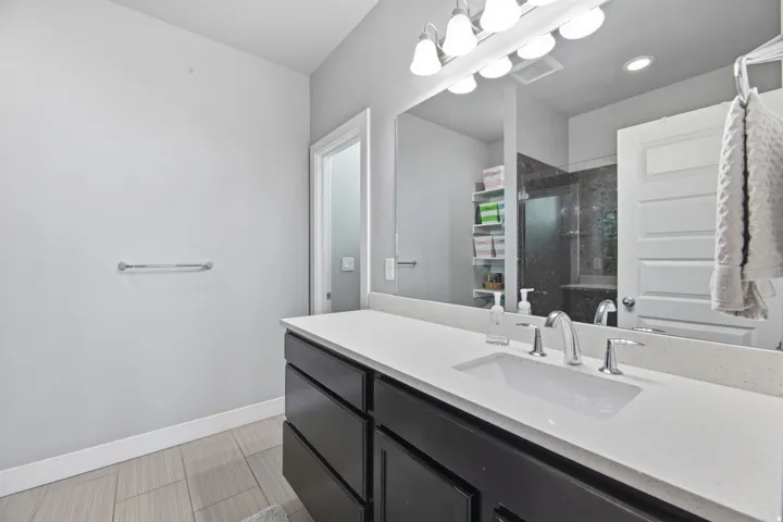 Double vanity with integrated sink, chrome fixtures, and a large mirror