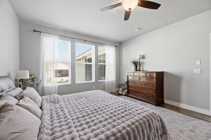 Vaulted ceilings, wood-finish flooring, and multiple windows with blinds