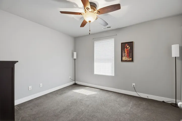Window with blinds, ceiling fan with light fixture, wall-to-wall carpeting, and light gray wall paint