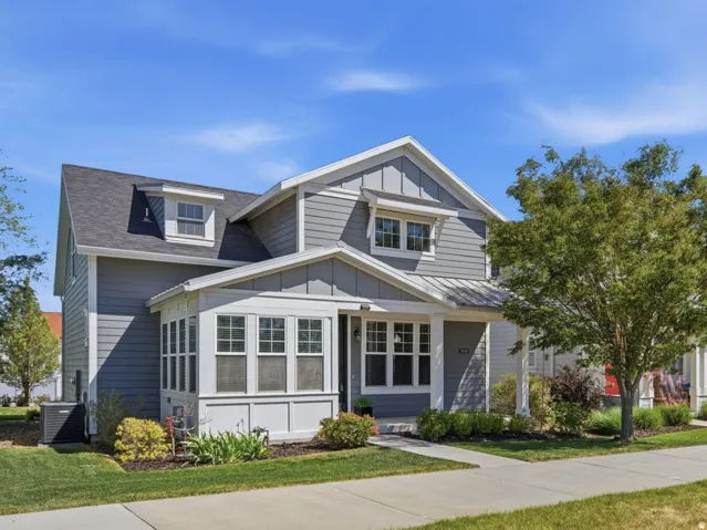 Contemporary exterior with gray siding, white trim, dormer windows, and covered entry