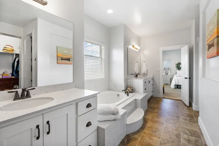 Dual vanity with integrated sinks, white cabinetry, and bronze-finish hardware