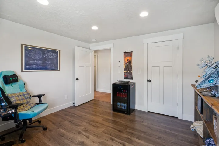 Wood-finish flooring, recessed lighting, white trim, and white paneled doors
