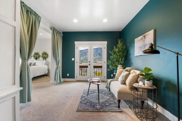Recessed lighting, white trim, wood-finish flooring, and glass-paneled French doors opening to a balcony
