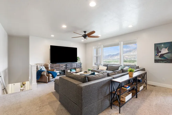 Argon gas filled windows, recessed lighting, ceiling fan, large windows, mountain backdrop, and carpeted flooring