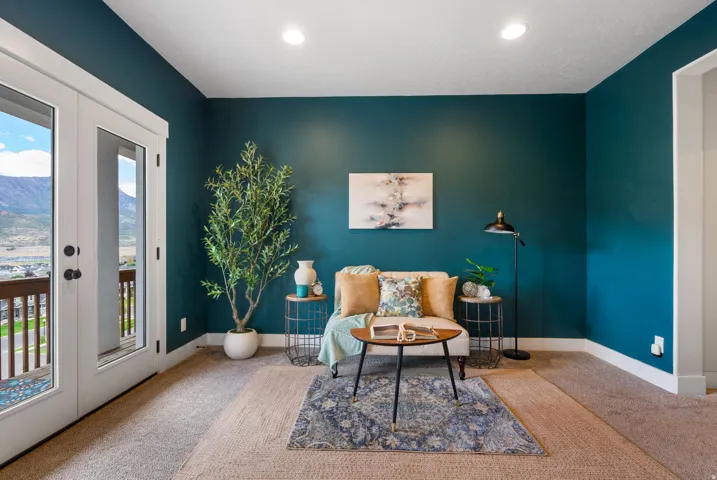 Dual glass-paneled doors with white trim, recessed ceiling lighting, and rich teal walls