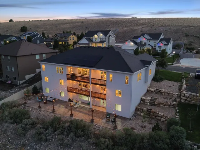 Multi-level exterior with a ground-level patio, two upper-level balconies, and a terraced rock garden