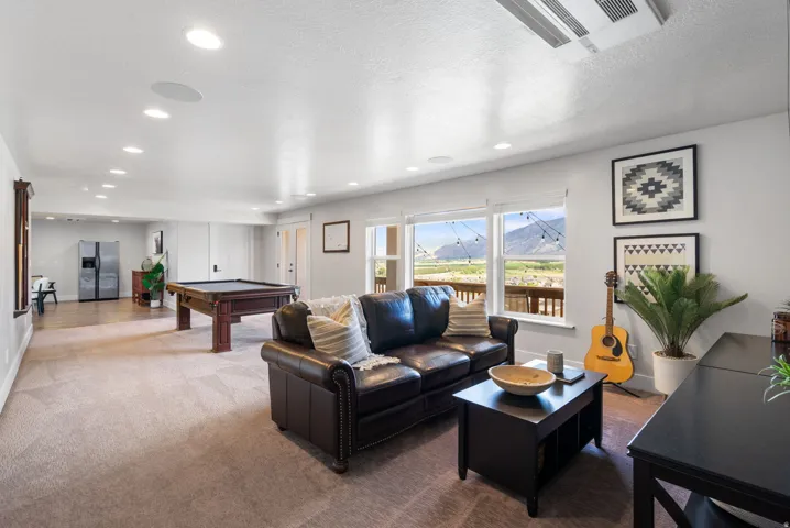 Spacious entertainment area with recessed lighting, carpeted flooring, and expansive windows