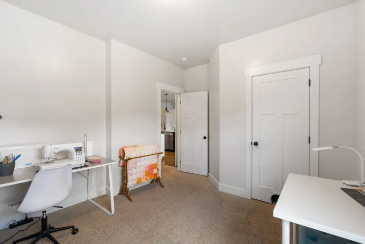 Light-toned carpeting, white interior doors with dark hardware, and bright white walls