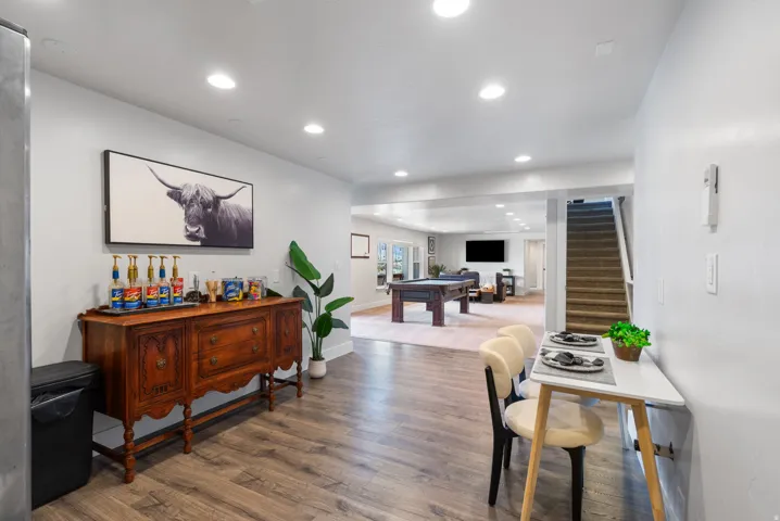 Potential kicthen area. Recessed lighting throughout, wood-finish flooring, and a separate stairwell