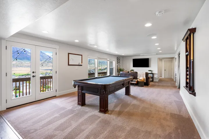 Dual French doors, recessed lighting, wall-mounted display rack, and large windows