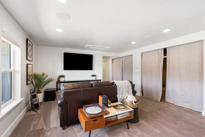 Recessed lighting, wall-mounted television, built-in ceiling speakers, window with blinds
