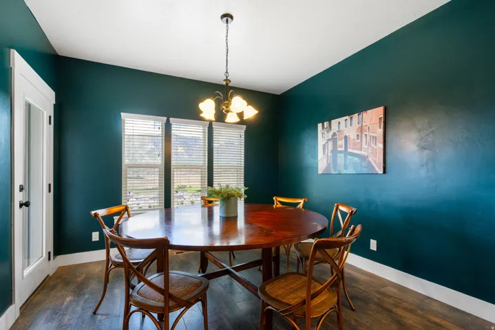 Argon gas filled windows, Dark teal accent wall, wood-finish flooring, white trim, frosted glass door