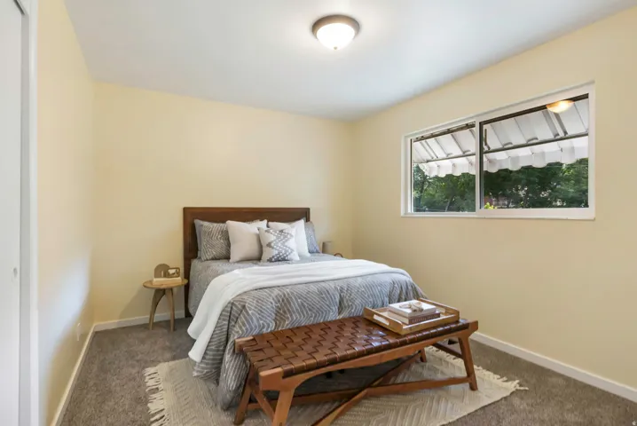 Neutral wall color, wall-to-wall carpeting, and a window with natural light
