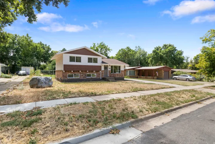 Split-level residence featuring a brick and siding exterior, multiple windows, and a concrete driveway