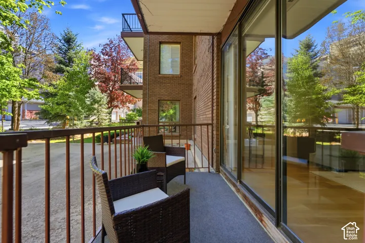 Balcony featuring a metal railing, sliding glass doors, and carpet flooring