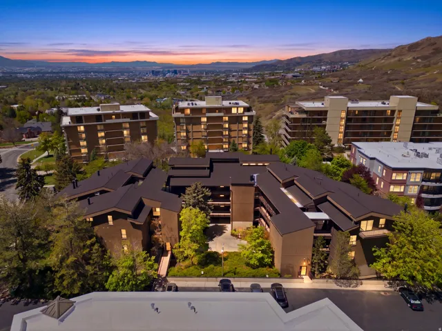 Aerial perspective showcasing multiple buildings, surrounding natural scenery, and a distant cityscape
