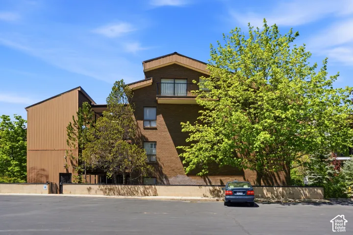 Brick and vertical panel exterior with multiple windows and an upper-level balcony