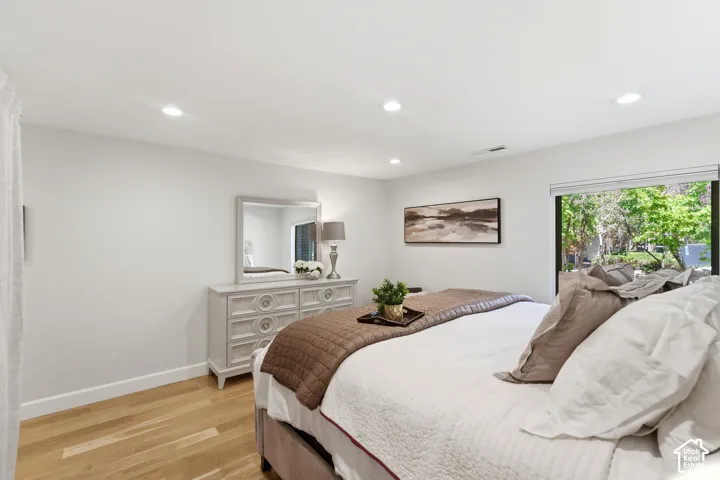 Recessed ceiling lighting, light wood-finish flooring, and a large sliding glass door