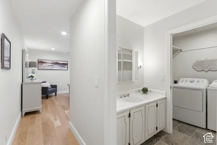 Hallway and Laundry Room featuring wood-finish flooring, recessed ceiling lighting, and a dedicated laundry area with full-size front-load washer and dryer