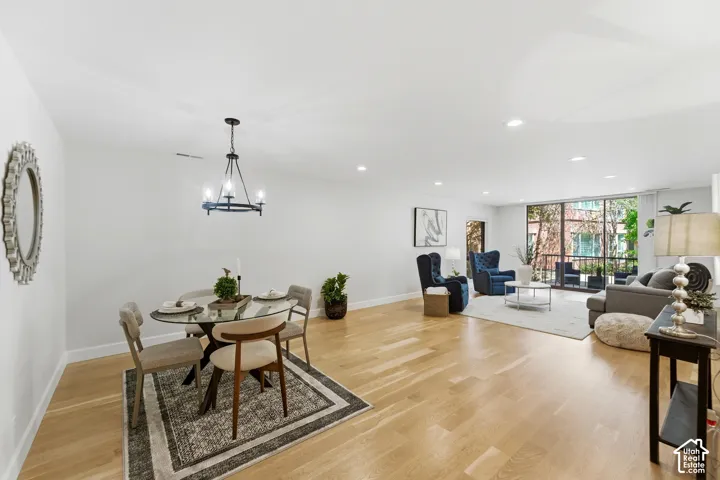 Open-concept living space featuring wood-finish flooring, recessed lighting, and a modern chandelier