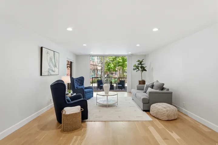 Hardwood-finish flooring, recessed lighting, and a private balcony with iron railings
