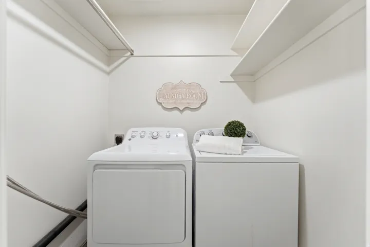 Integrated laundry area featuring shelving