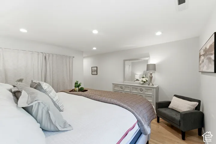 Recessed ceiling lighting, light wood-finish flooring, and window treatments