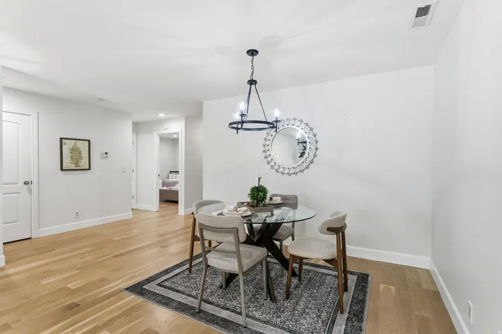 Hardwood-finish flooring, white walls, and a contemporary chandelier