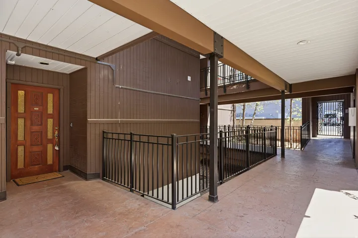 Entryway featuring a decorative wood-panel door, vertical wood siding, and concrete flooring