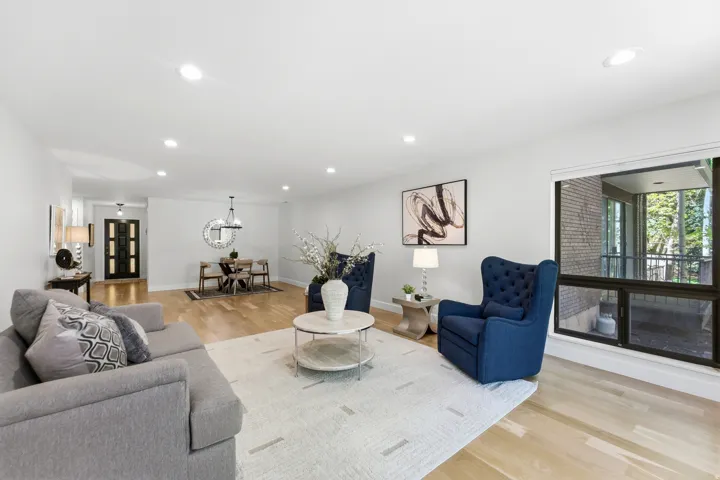 Recessed lighting, wood-finish flooring, a large multi-pane window, and a built-in entry door