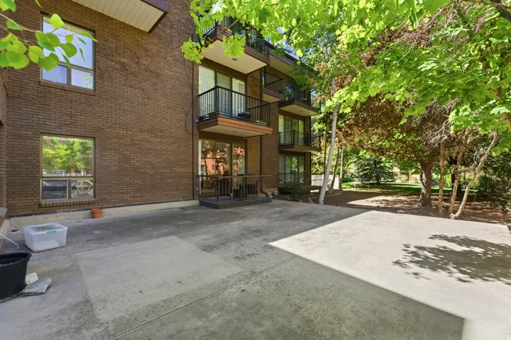 Brick exterior with multiple balconies and a ground-level patio