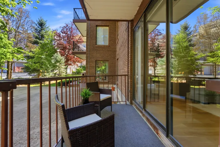 Balcony featuring a metal railing, sliding glass doors, and carpet flooring