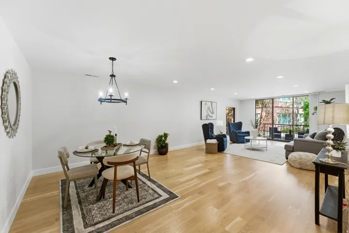 Open-concept living space featuring wood-finish flooring, recessed lighting, and a modern chandelier