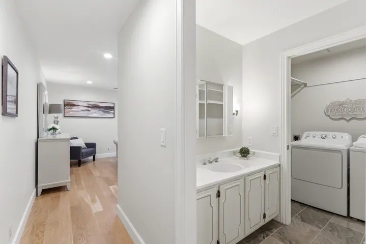 Hallway and Laundry Room featuring wood-finish flooring, recessed ceiling lighting, and a dedicated laundry area with full-size front-load washer and dryer