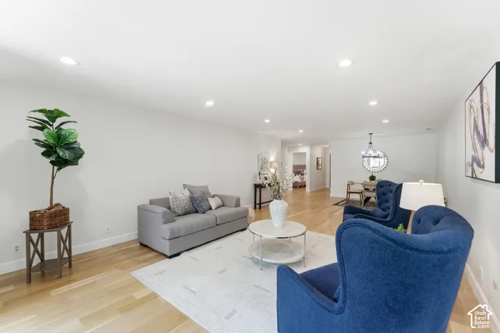 Recessed lighting, light-toned wood-finish flooring, and white walls