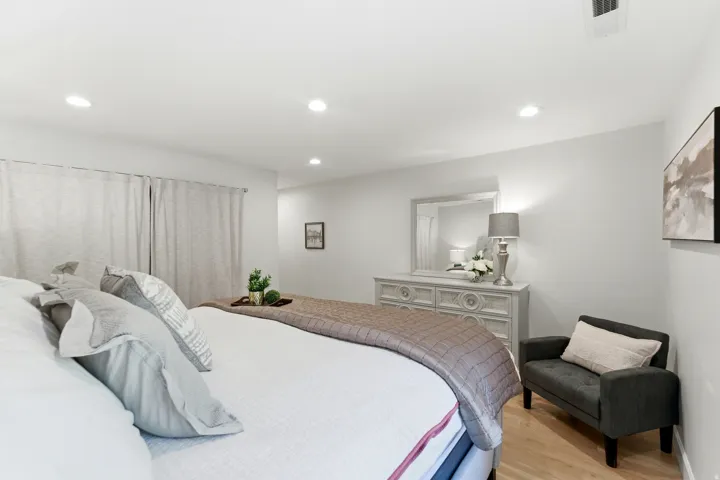 Recessed ceiling lighting, light wood-finish flooring, and window treatments