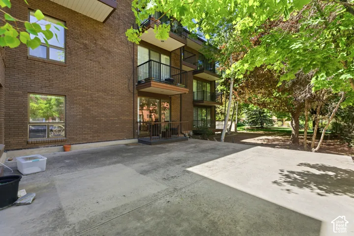 Brick exterior with multiple balconies and a ground-level patio