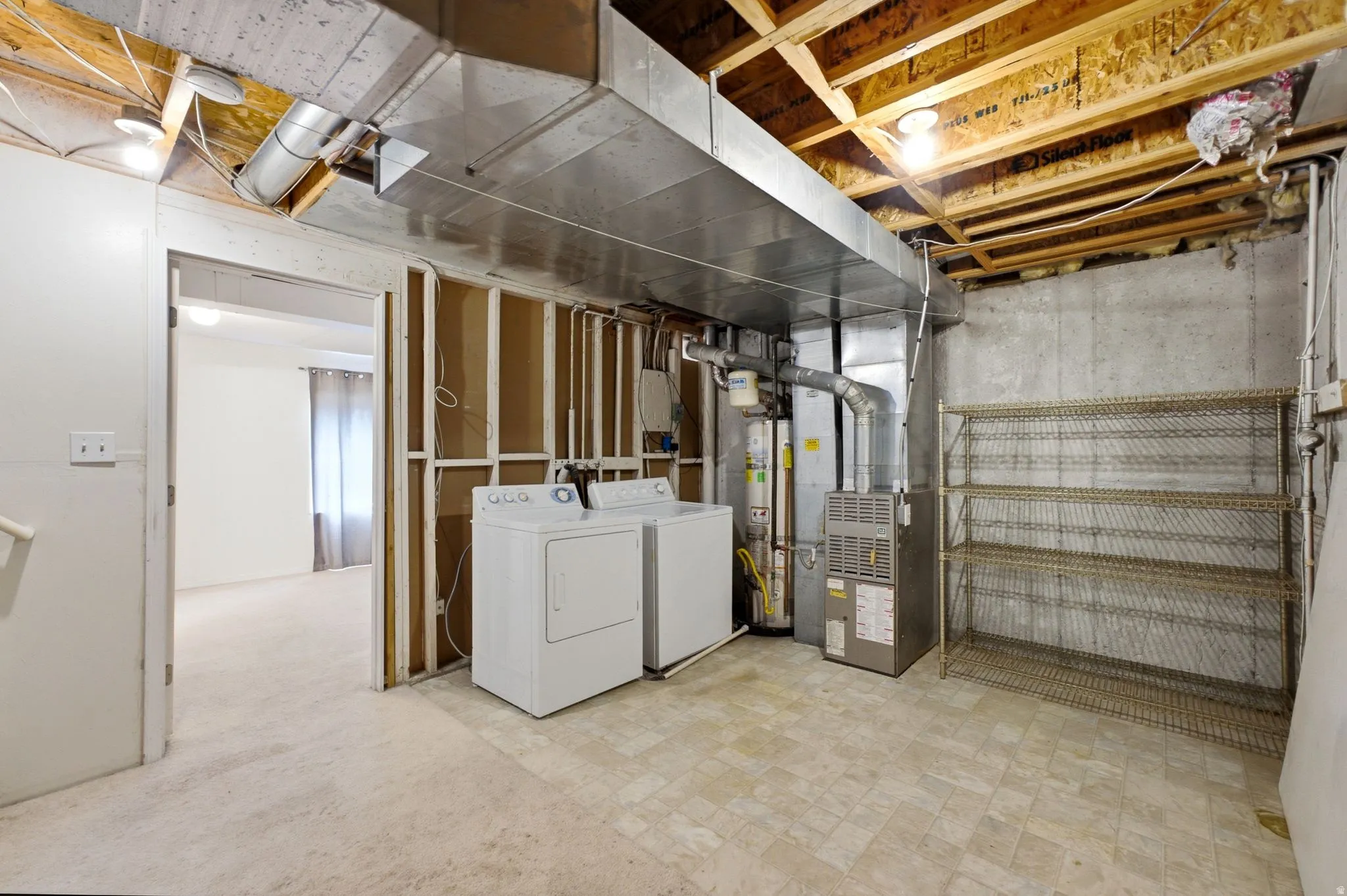 Utility space featuring a washer, dryer, furnace, and water heater