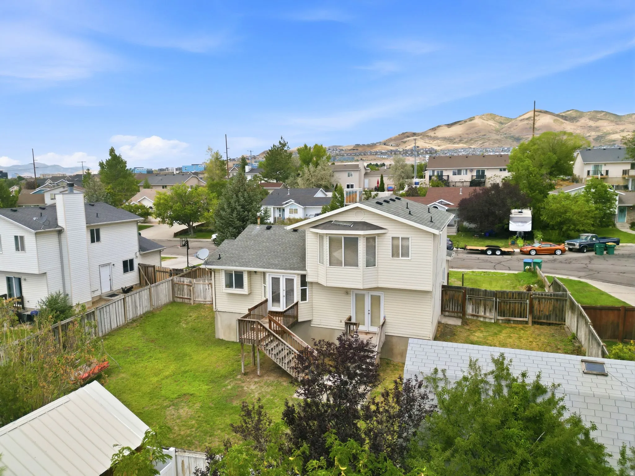 Two-story residence with a bay window, a rear deck, and a fenced backyard