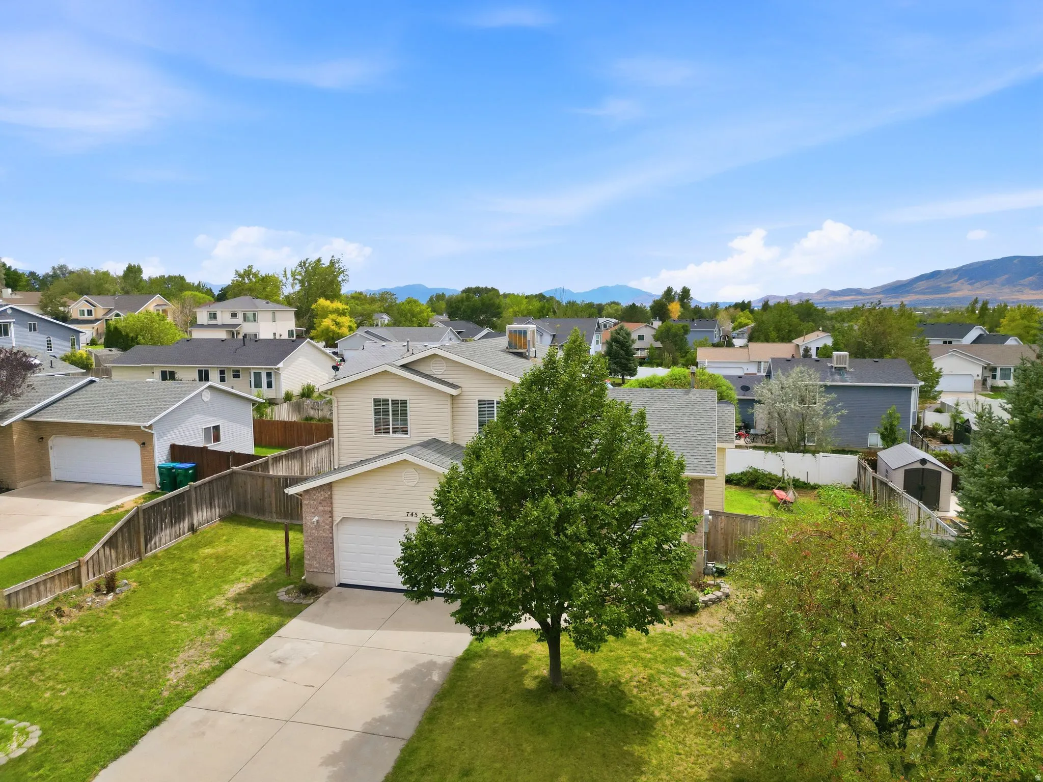 Two-story residence with a two-car garage, concrete driveway, and a fenced rear yard