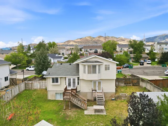 Expansive backyard featuring a wood fence, mature trees, and a multi-level deck with stairs
