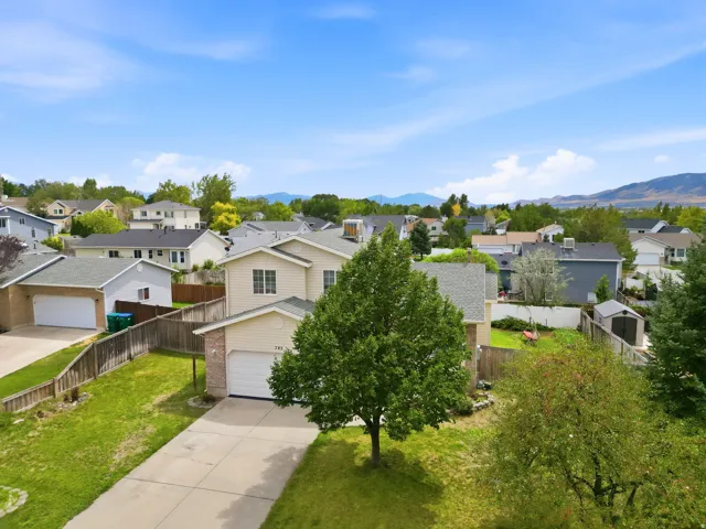 Two-story residence with a two-car garage, concrete driveway, and a fenced rear yard