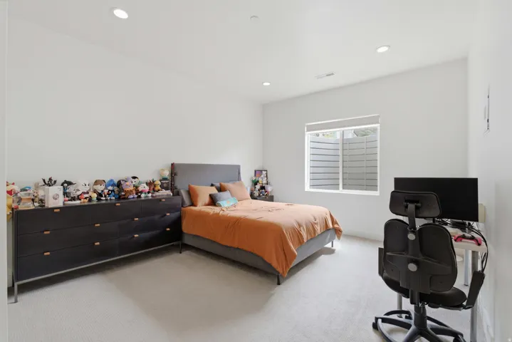 Recessed ceiling lighting, white walls, and light-toned carpeting