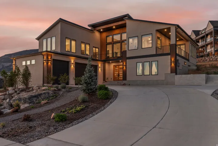 Contemporary exterior with multiple balconies, a multi-pane glass entry door, and an attached two-car garage
