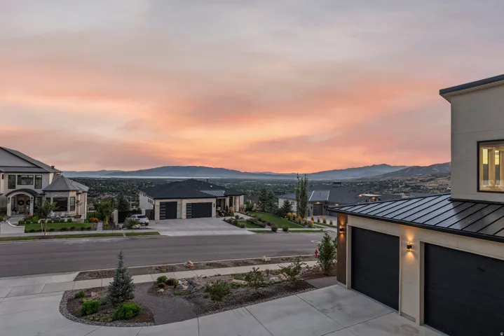 Contemporary architecture with a multi-car garage, concrete driveway, and cultivated landscaping